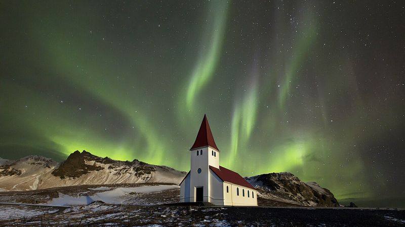 Noorderlicht boven een kerkje in IJsland