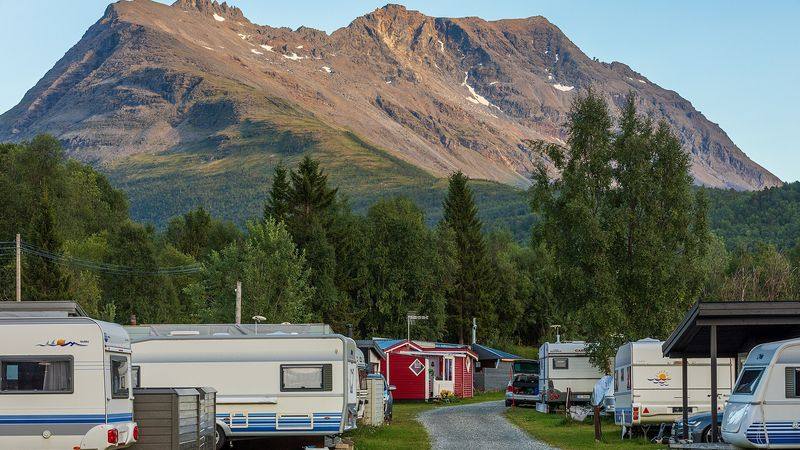 Caravans en huisjes op de camping van Hatteng in Storfjord (Troms), met de bergen erachter