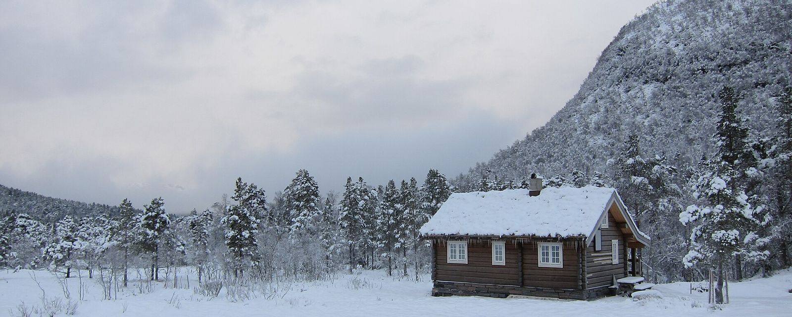 Traditionele Noorse houten hytte in de sneeuw bij Rekdalsetra